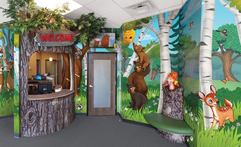 Themed reception area with sculpted tree desk area, woodland wall murals and corner bench seat with tree trunk and squirrel.