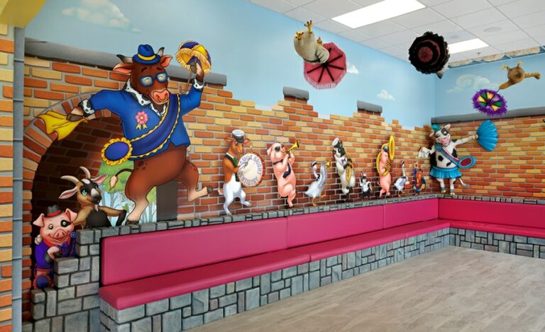 Musical mardi gras-themed waiting area with custom bench seating, sculpted animal characters and wall murals of animals playing instruments