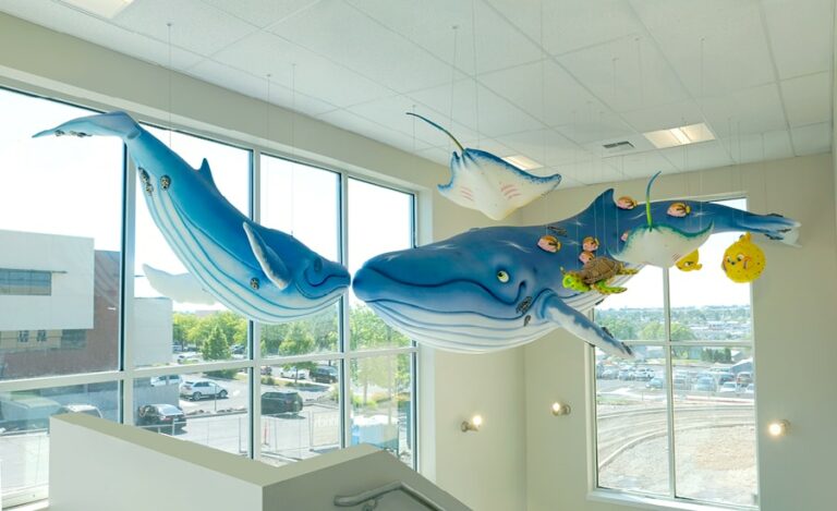 Large humpback whale sculptures suspended from the ceiling with other friendly sea creatures