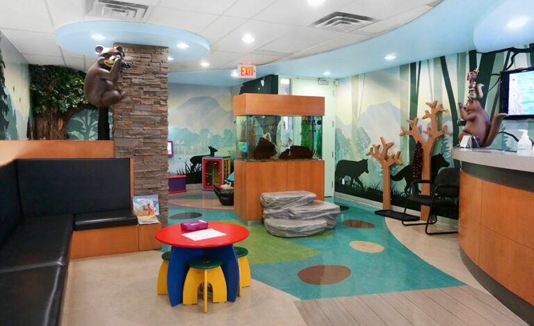 Woodland-themed waiting area with sculpted characters and rocks with a contemporary silhouette wall murals.