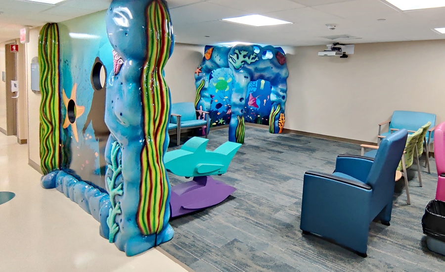 Waiting room area with underwater themed gazebo and wall divider with peek-through face portals for photo op as starfish and scuba diver