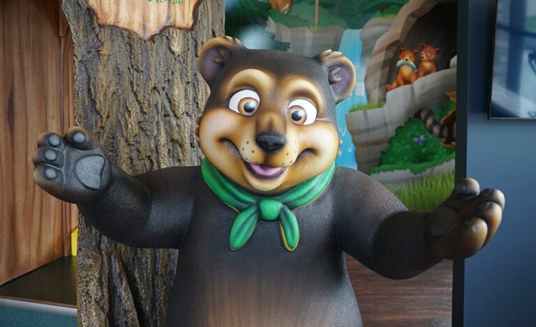 A welcoming, open-armed 3D sculpted bear