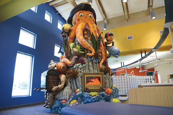 Gaming consoles built into an underwater themed feature tower in dental office
