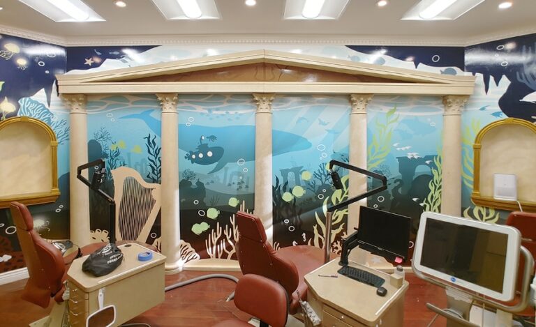 Atlantis-themed treatment room featuring a contemporary underwater mural and ornate columns.