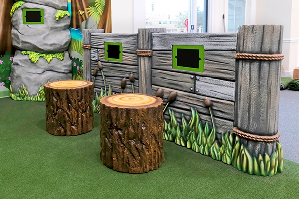 Wall mounted gaming systems in a forest themed play area.