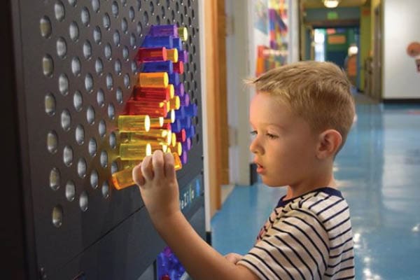 Boy playing with a LiteZilla wall.