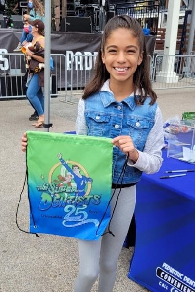 Smiling child presenting mascot swag drawstring bag