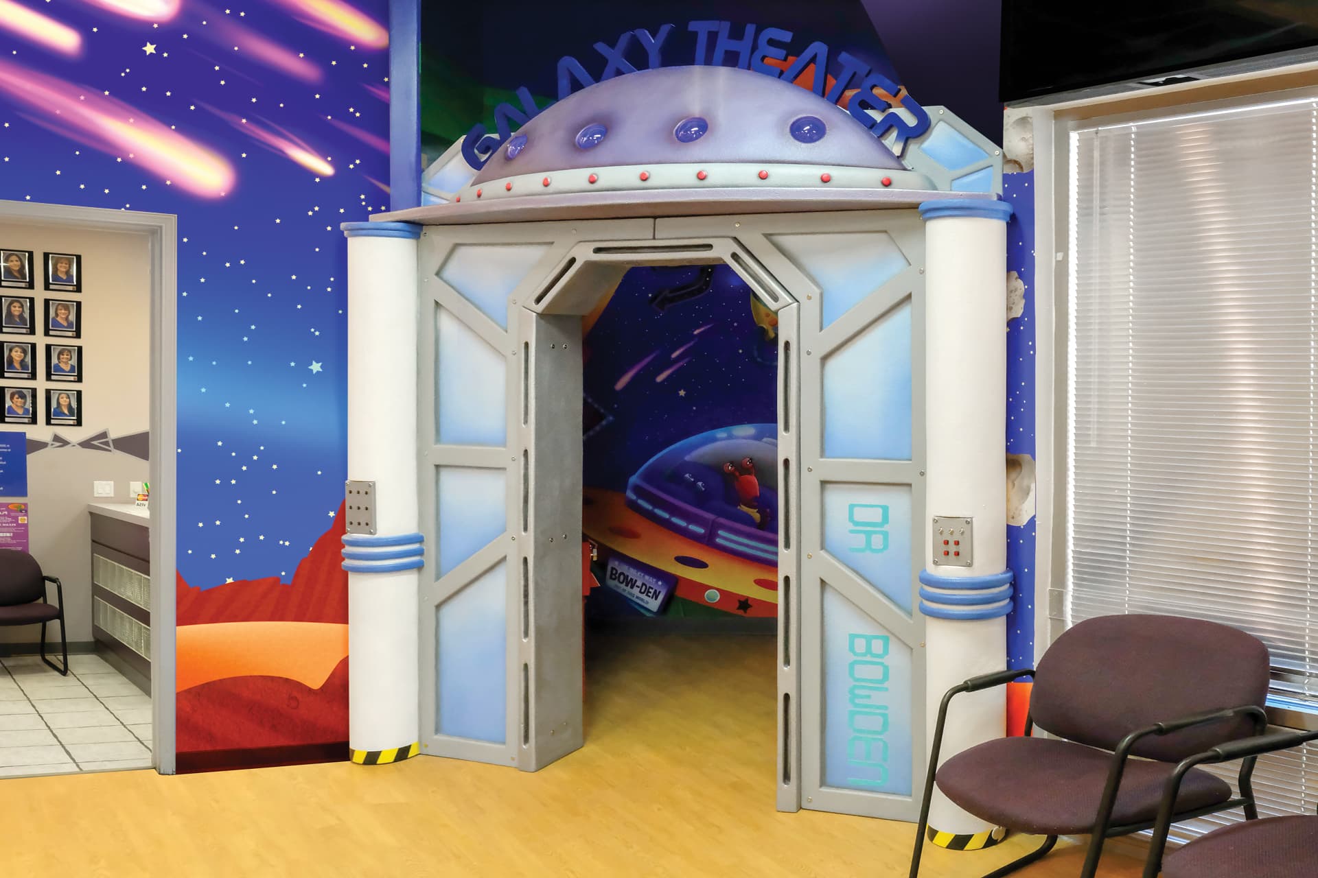 Experience a stunning themed environment transformation as the entrance becomes Galaxy Theater, featuring sci-fi decor. See the before and after: a waiting area with chairs, a counter, and vivid space murals of rockets and stars.