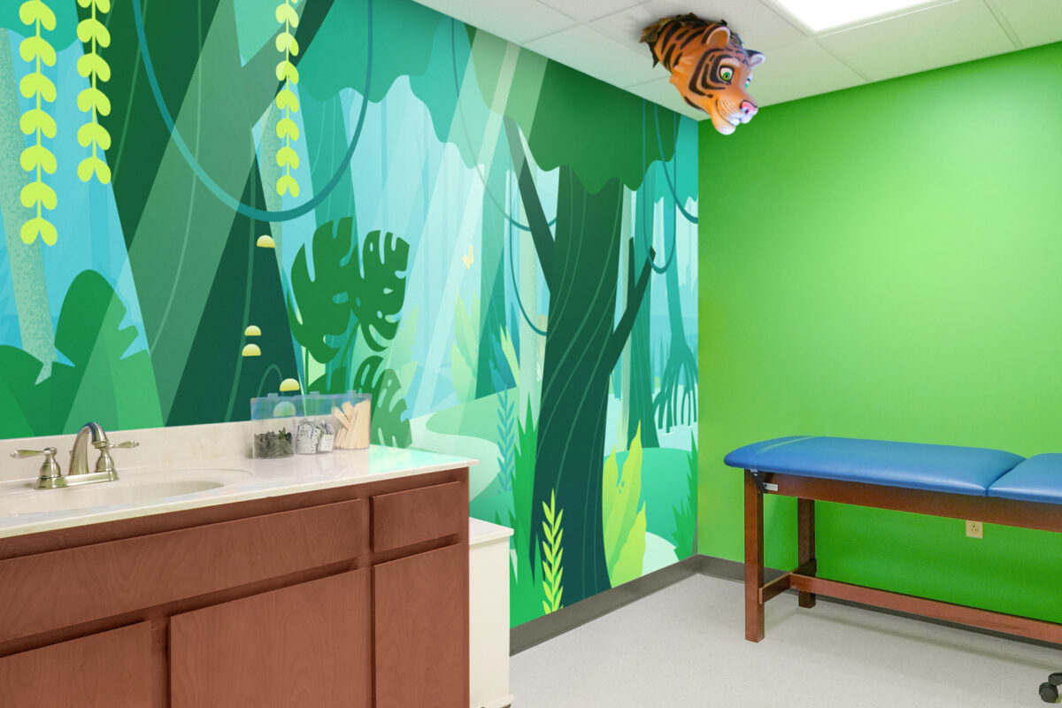 Experience a themed environment transformation in this children's medical exam room, featuring a jungle-themed wall mural, green walls, a blue exam table, wooden cabinet with sink, and a tiger head decoration hanging from the ceiling.