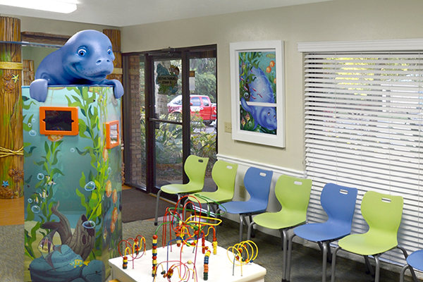 Underwater river themed waiting area with gaming pad tower, sculpted manatee and faux window mural