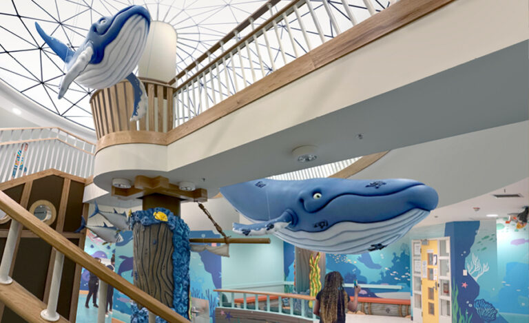 View of ocean themed hospital with sculpted whales, coral and underwater wall murals.