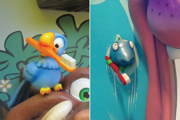Two cartoon animals, a blue bird and a blue fish, each holding a toothbrush, are displayed on colorful backgrounds. The bird stands on a brown object, and the fish peeks out of a blue surface. Both appear cheerful.