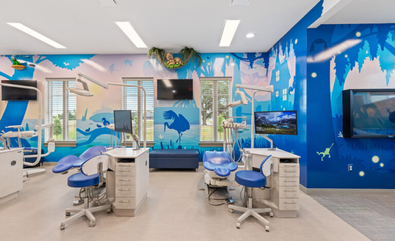 A brightly lit pediatric dental office features blue dental chairs, cabinets, and playful bayou-themed wall murals with animals. Large windows and multiple TV screens create a welcoming, cheerful atmosphere.