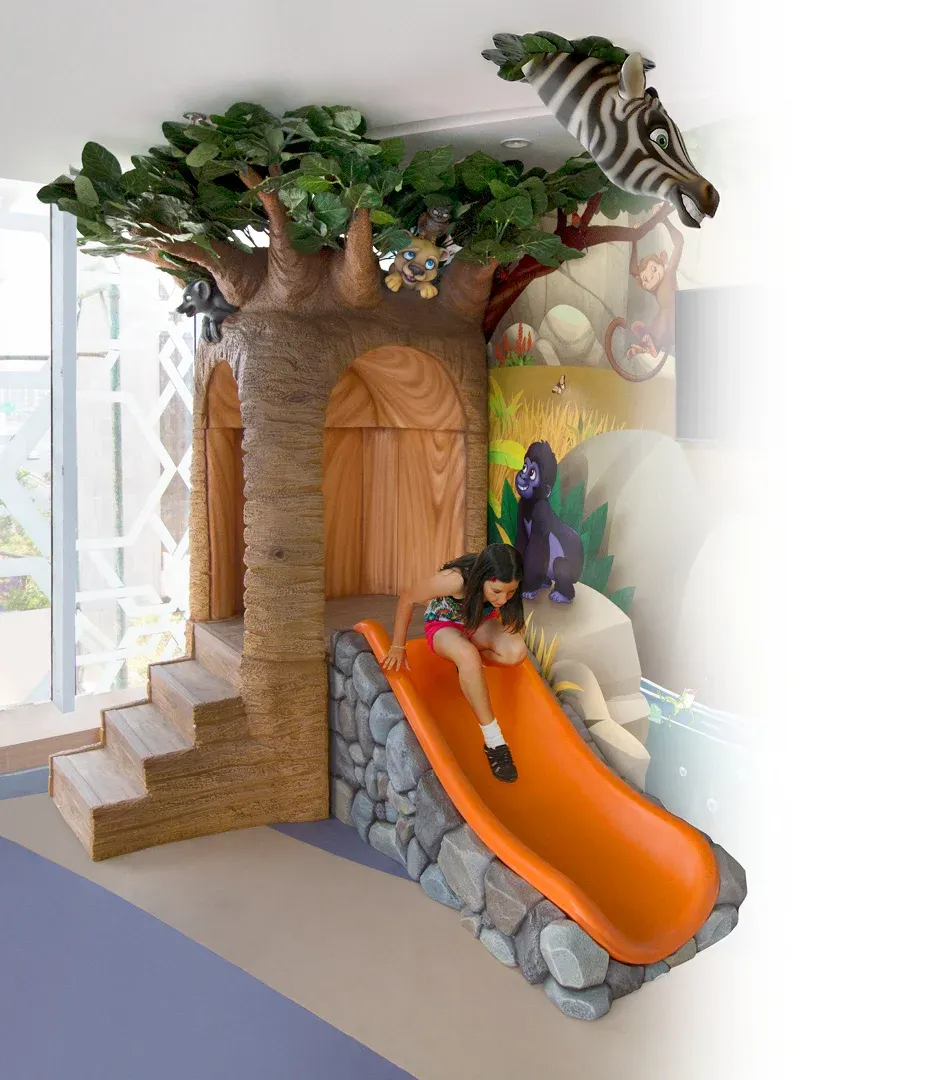 Treehouse and indoor slide themed children's play area designed for pediatric hospital environment