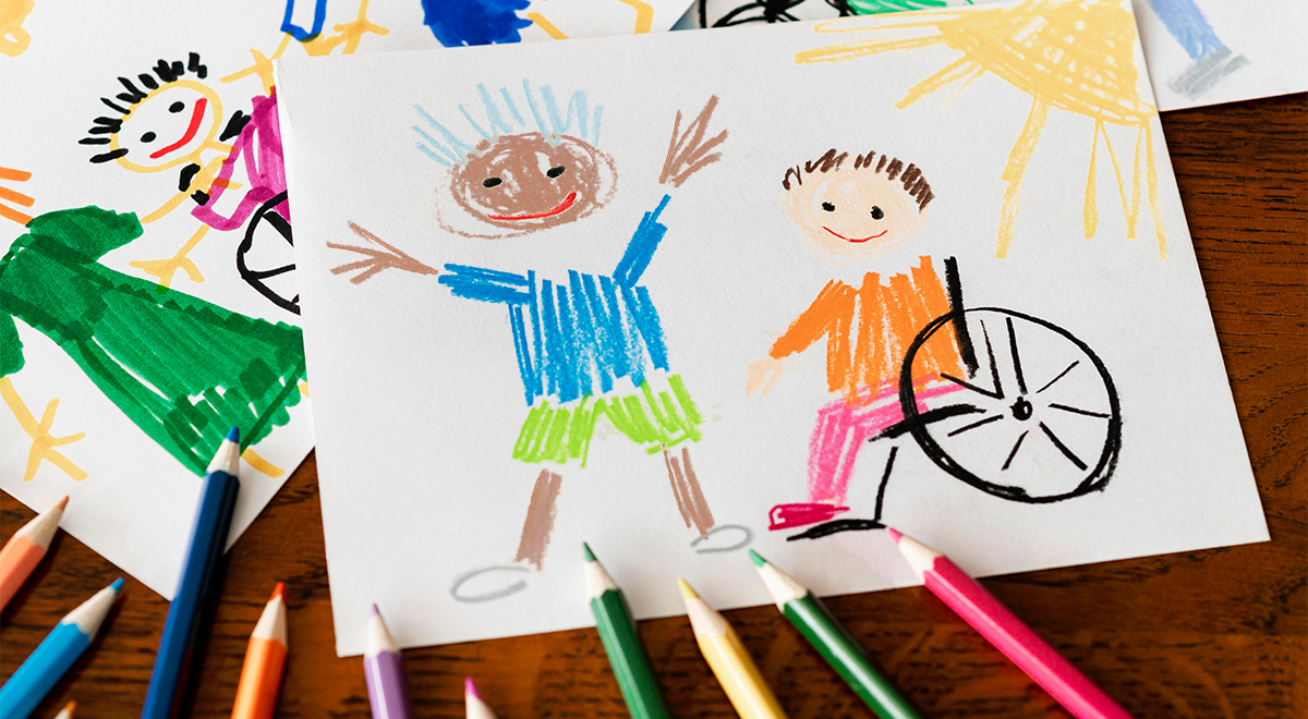 Children’s drawings of happy kids, including one child using a wheelchair, with colored pencils scattered on a wooden table. The vibrant artwork celebrates diversity and friendship through inclusive design.
