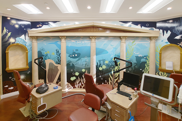 A dental office with red chairs and dental equipment, featuring an underwater-themed mural with sea creatures and plants, and columns resembling an ancient Greek temple.