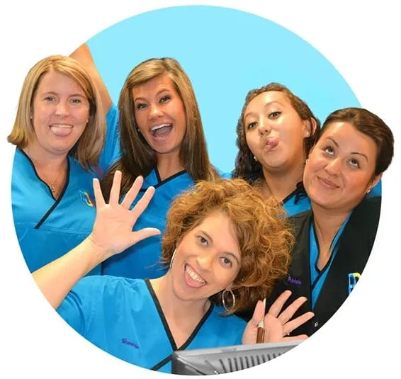Team of women in blue uniforms smiling and posing together