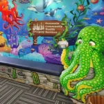 Colorful underwater-themed waiting area transformed with vibrant sea creature murals and a large green octopus sculpture holding a “Cavity Free” sign. Experience a themed environment transformation at Peninsula Community Health Services.
