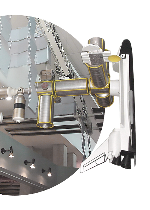 A model of a space shuttle docked to a space station module hanging from the ceiling of a zoo or aquarium.